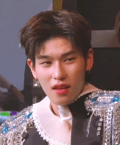 a close up of a young man wearing a black jacket with rhinestones on the sleeves .