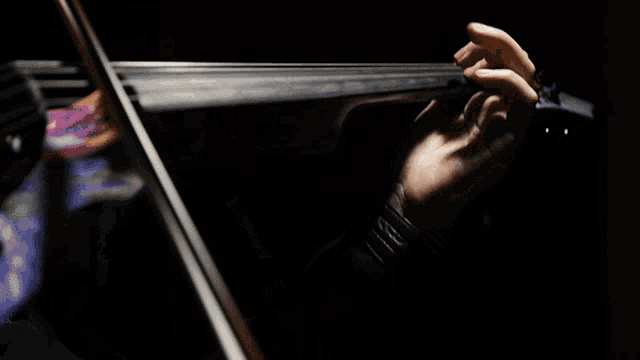 a person playing a violin with a black background