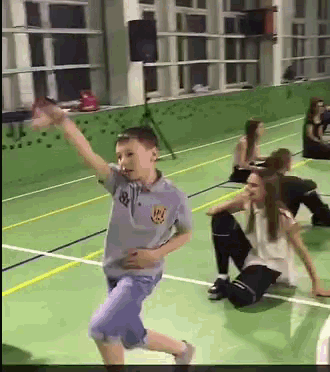 a boy in a blue shirt with the letter r on it is dancing