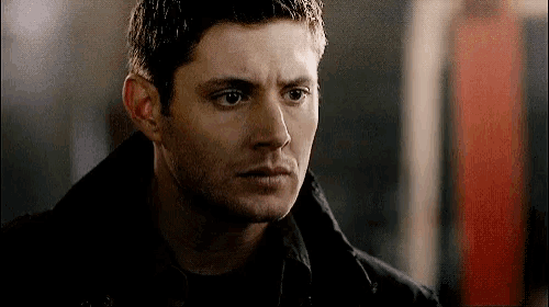 a close up of a man 's face with a black jacket on looking at the camera .