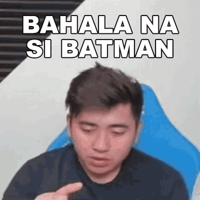 a man is sitting in a chair with his eyes closed and a sticker that says bahala na si batman on his face .