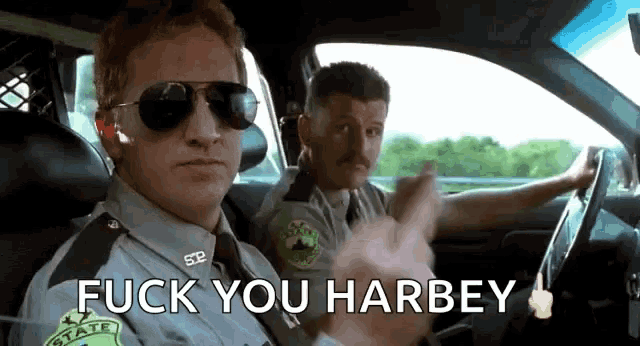 two police officers in a car with the words fuck you harbey