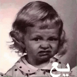 a black and white photo of a little girl with a very angry face .