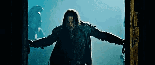 a man with a beard is standing in a doorway with his arms outstretched