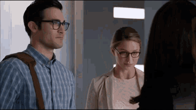 a man and a woman wearing glasses are standing next to each other .