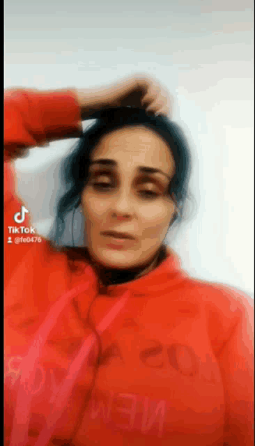 a woman wearing a red hoodie with the number 20 on the chest