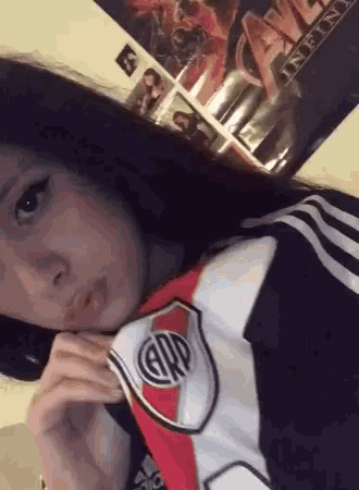 a girl is taking a selfie with a river plate jersey