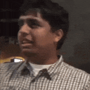 a man in a plaid shirt is making a face