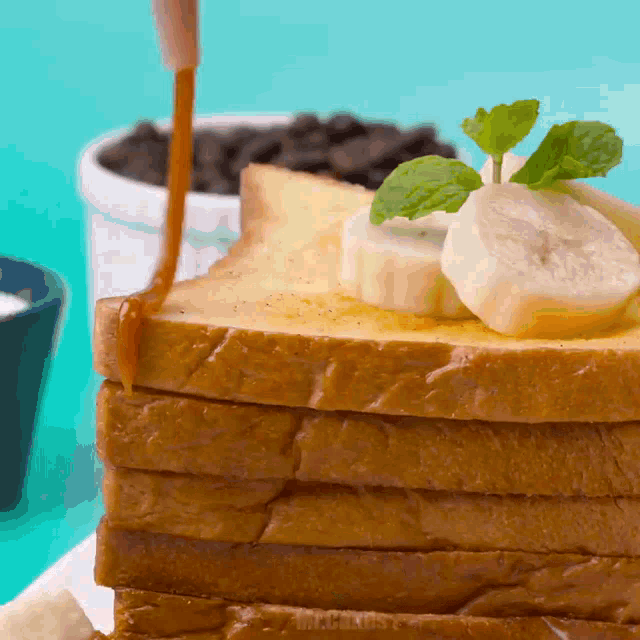 a stack of slices of toast with bananas and syrup on top