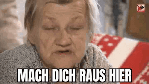 an elderly woman is sitting on a couch with her eyes closed and making a face .