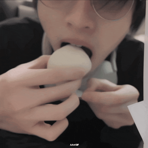 a close up of a person eating something with the words aa + gif on the bottom right