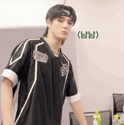 a young man wearing a headband and a black shirt stands in a room