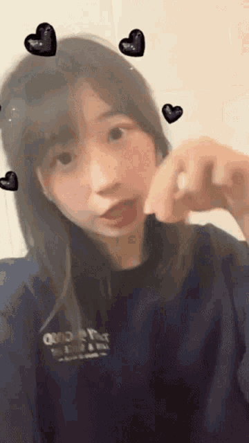 a girl taking a selfie with hearts around her head and a shirt that says o'neill on it