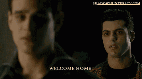two men are standing next to each other and the words welcome home are on the bottom right