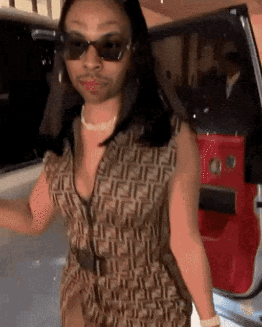 a woman wearing sunglasses and a fendi dress
