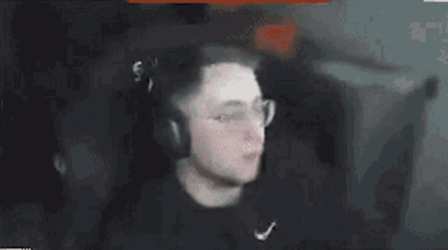 a man wearing headphones and glasses is smoking a cigarette in a video game .