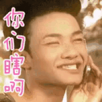 a man is smiling while talking on a cell phone