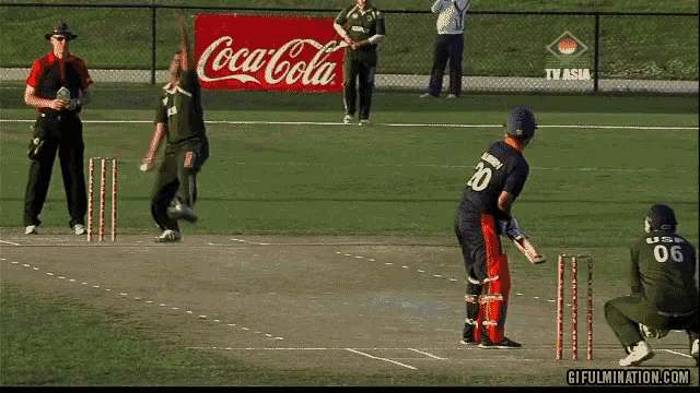 a coca cola sign is behind a cricket player