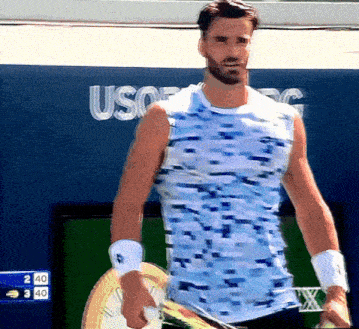 a man holding a tennis racquet in front of a sign that says usa