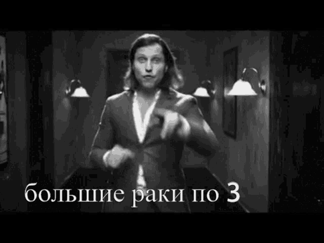 a man in a suit is standing in a hallway with the words " большие раки по 3 " written on the bottom