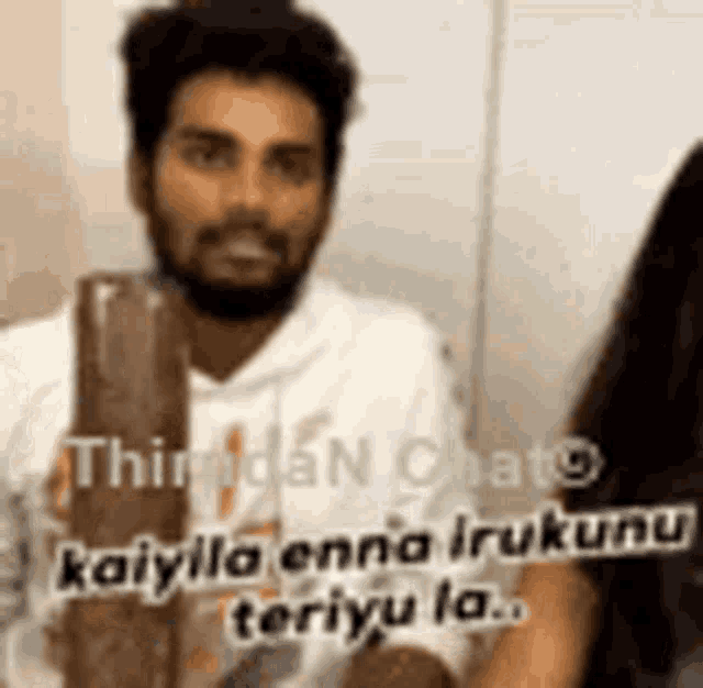 a man with a beard is talking to a woman while holding a bottle of chocolate .