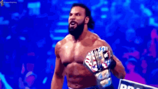 a shirtless wrestler is holding a wrestling championship belt in his hand .