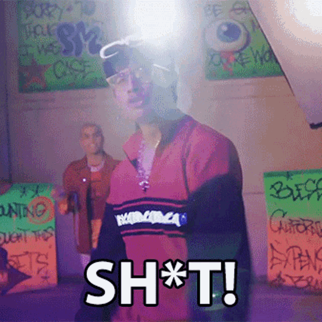 a man in a red shirt says sh * t in front of graffiti