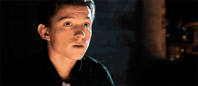 a close up of a young man 's face with a surprised look on his face .