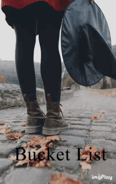 a person standing on a cobblestone road holding a witch hat with the words bucket list on the bottom