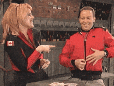 a woman with a canadian flag on her jacket talks to a man