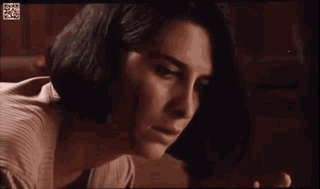 a close up of a woman 's face in a movie looking at something .