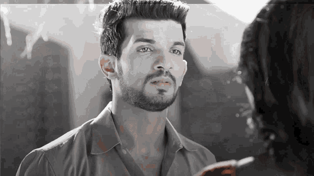 a man with a beard is looking at another man