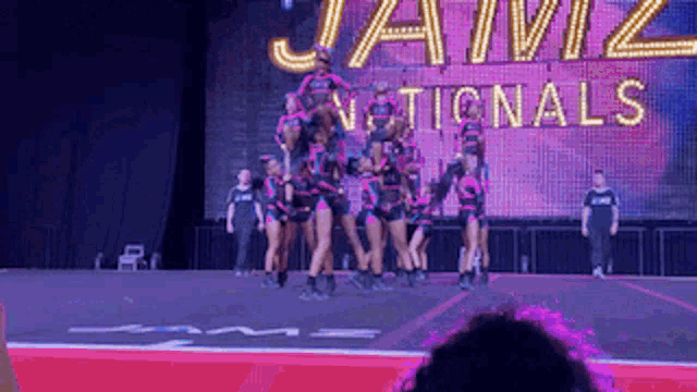 a group of cheerleaders are performing in front of a large sign that says jamz nationals