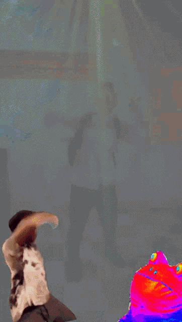a man in a white shirt is dancing in a room with purple lights