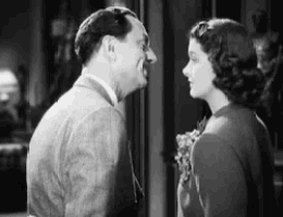 a man and a woman are standing next to each other and looking at each other .
