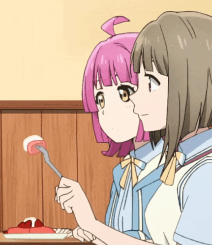 a girl with pink hair is holding a fork next to another girl with brown hair