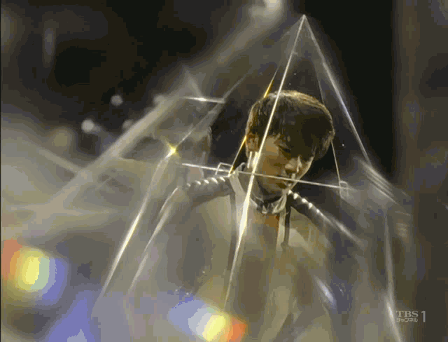 a man is surrounded by a clear pyramid with the tbs logo on the bottom