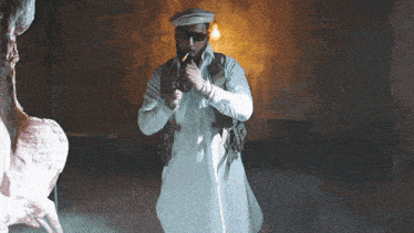 a man in a white robe is smoking a cigarette in a dark room