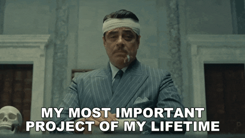 a man with a bandage on his head is smoking a cigarette and says " my most important project of my lifetime "