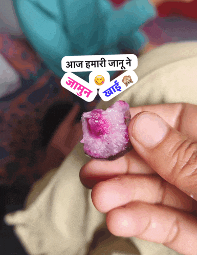 a person holding a piece of food with a sticker that says ' aaj '