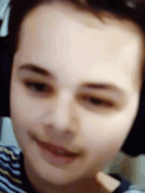 a blurry picture of a person 's face with a striped shirt on
