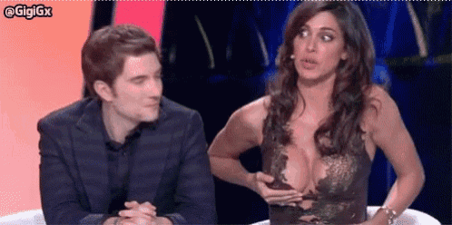 a man and a woman are sitting next to each other and the woman has a very large breast