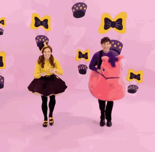 a man and a woman are dancing in front of a pink background