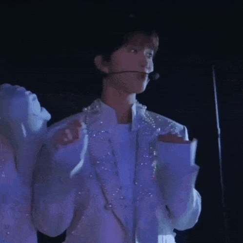 a man in a white jacket with a microphone on his ear