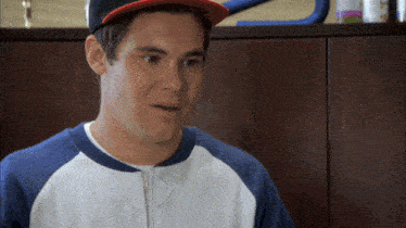 a man wearing a baseball cap and a blue and white jacket looks surprised