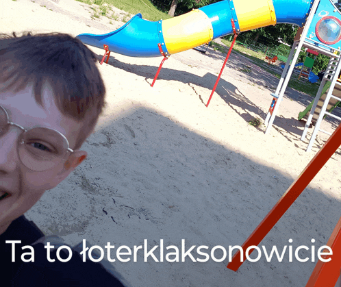 a boy taking a picture of himself in front of a playground with the words ta to toterklaksonowicie written below him