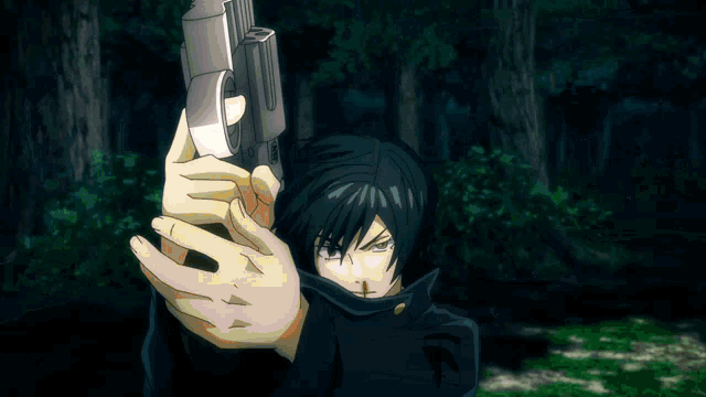 a man in a black jacket holds a gun in front of his face