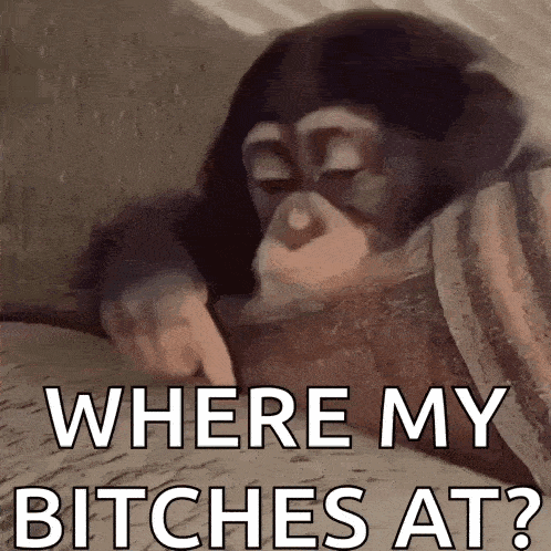 a baby chimpanzee is laying on a bed and pointing at something .