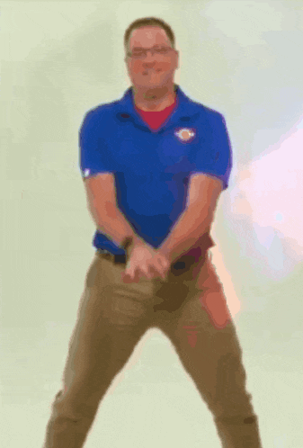 a man in a blue shirt and khaki pants is standing with his arms outstretched