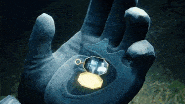 a person is holding a locket in their hand with a picture of a family inside of it .